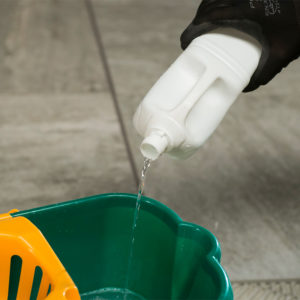 наливаем моющее средство в ведро для мытья керамогранитной плитки